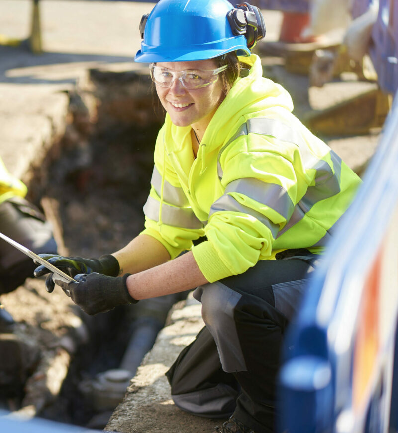 a female gas engineer holds a new gas valve as she and a colleague prepare to replace the old pipework in a residential uk street .