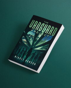 A paperback book titled "The Vanguard Project" by Nikole Hanson lies on a dark green surface. The cover features silhouettes of people, futuristic cityscapes, and glowing green geometric shapes.
